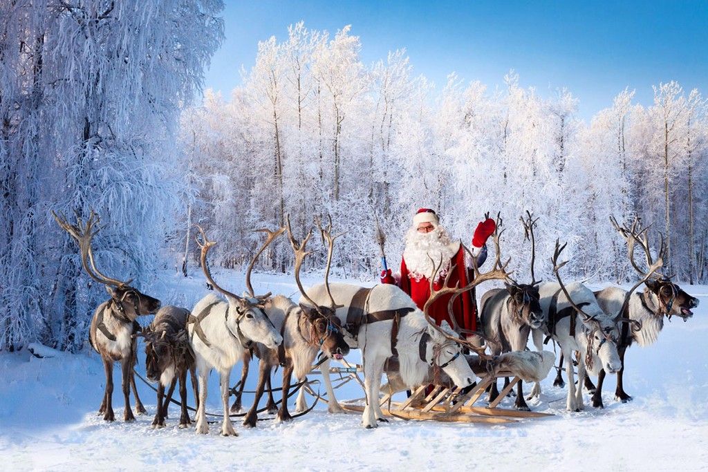 Le Père Noël avec des rennes au village